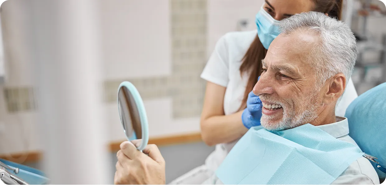 Paciente sorrindo com espelho na mão
